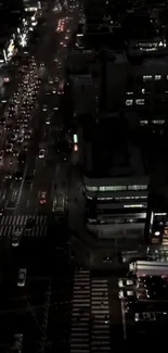 Aerial view of a city at night with bustling streets and lights.