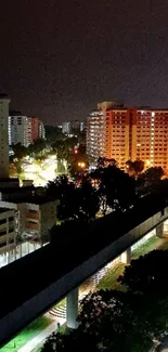 Night cityscape featuring illuminated buildings and streetlights.