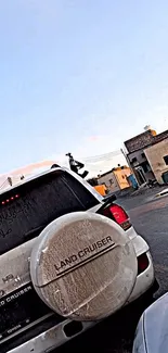 Land Cruiser parked in urban setting with clear morning sky.