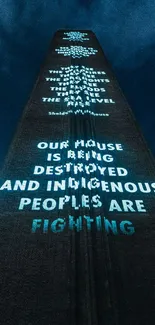 Projection art on building with illuminated messages against night sky.