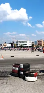 Urban race track with tires and city backdrop.