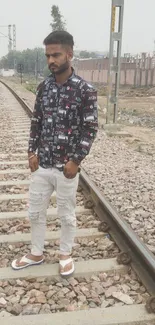 Young man on railway track in urban fashion.