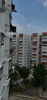 Urban residential skyline with city buildings against a blue sky.