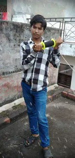 Young man kite flying on rooftop, urban style.