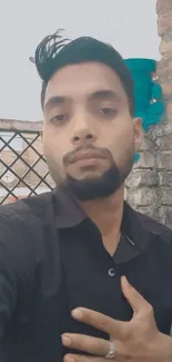 Urban selfie of man on rustic rooftop in black shirt.