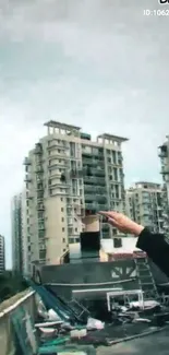 Rooftop view of towering urban skyscrapers against a cloudy sky.