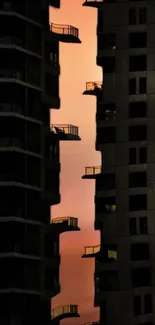 Modern city buildings silhouetted against a vibrant sunset sky.