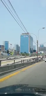 City skyline with highway under clear blue sky.