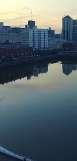 Peaceful cityscape reflecting on water at dusk with modern skyline in view.