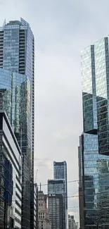 Modern urban skyline with reflective glass buildings under a clear sky.