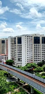 Urban buildings under a blue sky with lush greenery.