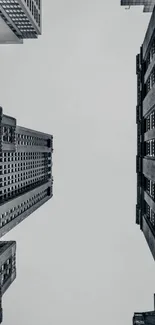 Monochrome view of skyscrapers from ground level with a cloudy sky.