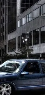 Blue car on city street with buildings in the background.