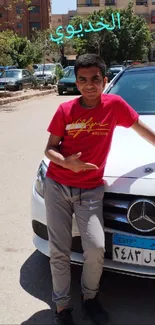 Youth posing with car in urban landscape, bright summer day.