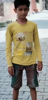 Young boy in yellow shirt on urban street wallpaper.