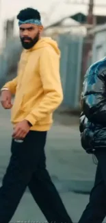 Two men in urban street fashion on a city sidewalk.