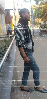 Man in striped shirt and jeans on urban street.