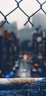 Moody urban street view with chain-link fence and blurred city lights.