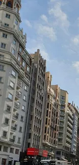 Bustling urban street with tall buildings against a light blue sky.