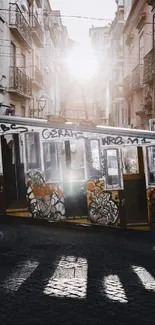 Graffiti-covered streetcar at sunrise on cobblestone street.