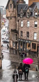 Urban street scene with pink umbrella, cobblestones, and historic buildings.