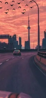 Urban sunset cityscape with highway and pink sky.