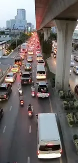 Bustling urban traffic scene with cars and elevated highway in city.