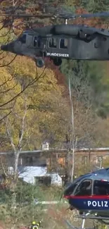 Helicopters flying over autumn forest landscape.