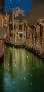 Venetian canal at night with warm streetlights reflecting on the tranquil water.