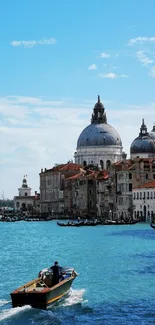 Scenic view of Venice canal with boat and historic buildings under blue sky.