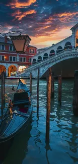 Venice gondola at sunset near bridge with vibrant sky.