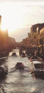 Venetian sunset over a canal with boats and historic buildings.