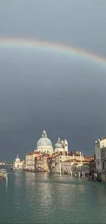 Venice canal under a rainbow with historic buildings.