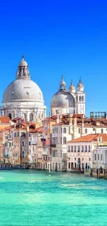 Venice canal with iconic architecture under a bright blue sky.