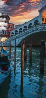 Venice gondola at sunset under bridge.