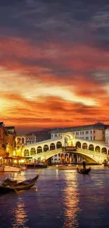 Venetian sunset over Rialto Bridge with city lights reflecting on the water.