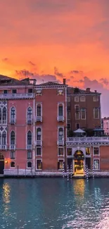 Beautiful Venice sunset view with orange sky and historic buildings.