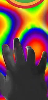 Hand silhouette over vibrant rainbow pattern wallpaper.