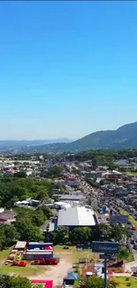 Aerial view of a vibrant cityscape with clear sky and lush greenery.