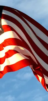 American flag waving against a blue sky wallpaper.