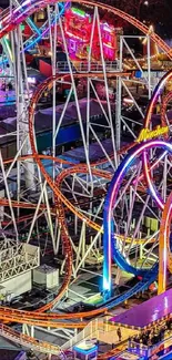 Colorful amusement park rollercoaster at night with vibrant lights.