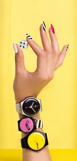 Hand with bold watches and nails against yellow background.