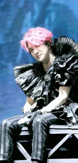 Artistic stage performance with pink hair and vibrant backdrop.