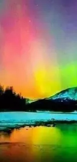 Colorful aurora borealis over snowy mountain and reflected in water.