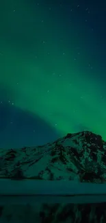 Aurora Borealis illuminating mountain under a star-filled night sky.