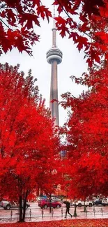 Autumn cityscape with vibrant red trees framing a prominent tower.