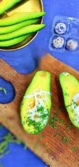 Sliced avocados with eggs on a wooden board and blue background.