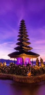 Balinese temple under a vibrant purple dusk sky, reflecting on serene waters.