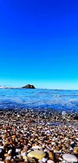 Vibrant beach with clear blue sky and pebbled shore.