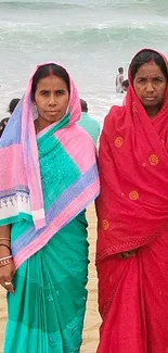 Two women in colorful attire at the beach.